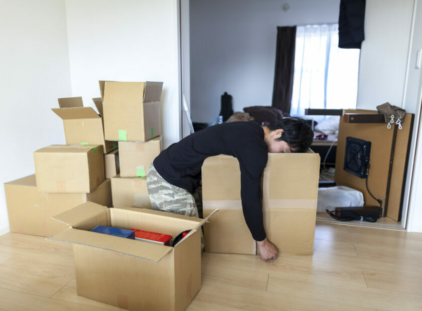 Tired man in new house with boxes